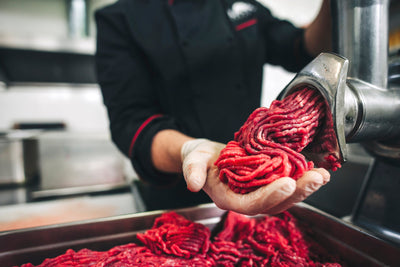 Minced beef being prepared using a commercial meat grinder